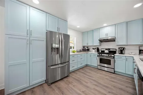 a kitchen with a refrigerator and a stove top oven