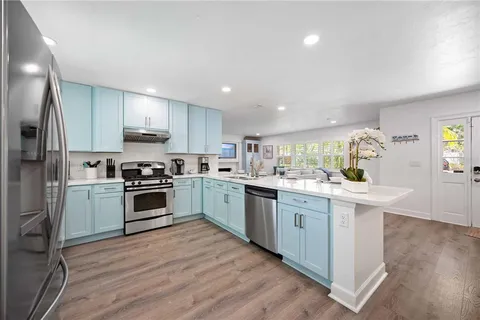 a kitchen with white cabinets stainless steel appliances and sink