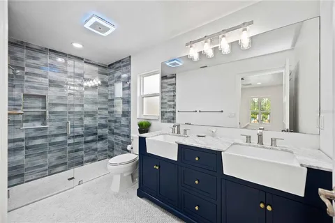 a bathroom with a bathtub shower sink mirror and toilet