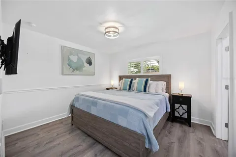 a spacious bedroom with a bed and a flat screen tv