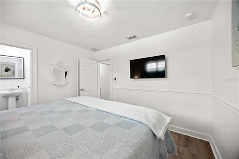 a bedroom with a bed and a flat screen tv