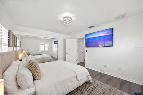 a bedroom with a bed and a painting on the wall