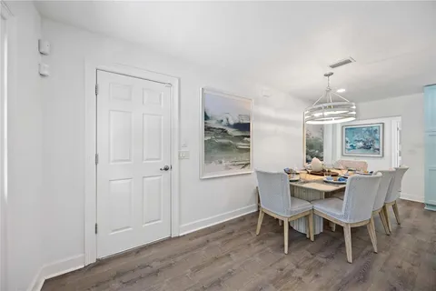 a dining room with furniture a chandelier and wooden floor