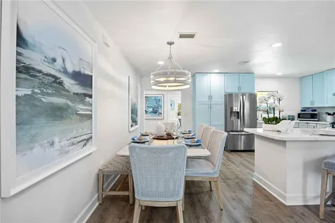 a dining room with furniture a chandelier and wooden floor