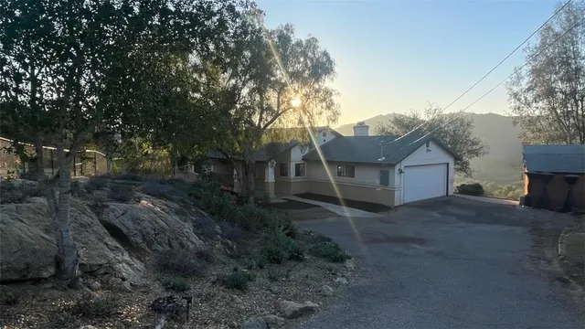 a view of a house with a yard and large tree