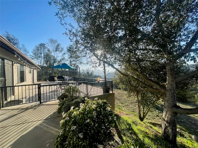 a view of a terrace with furniture and a garden