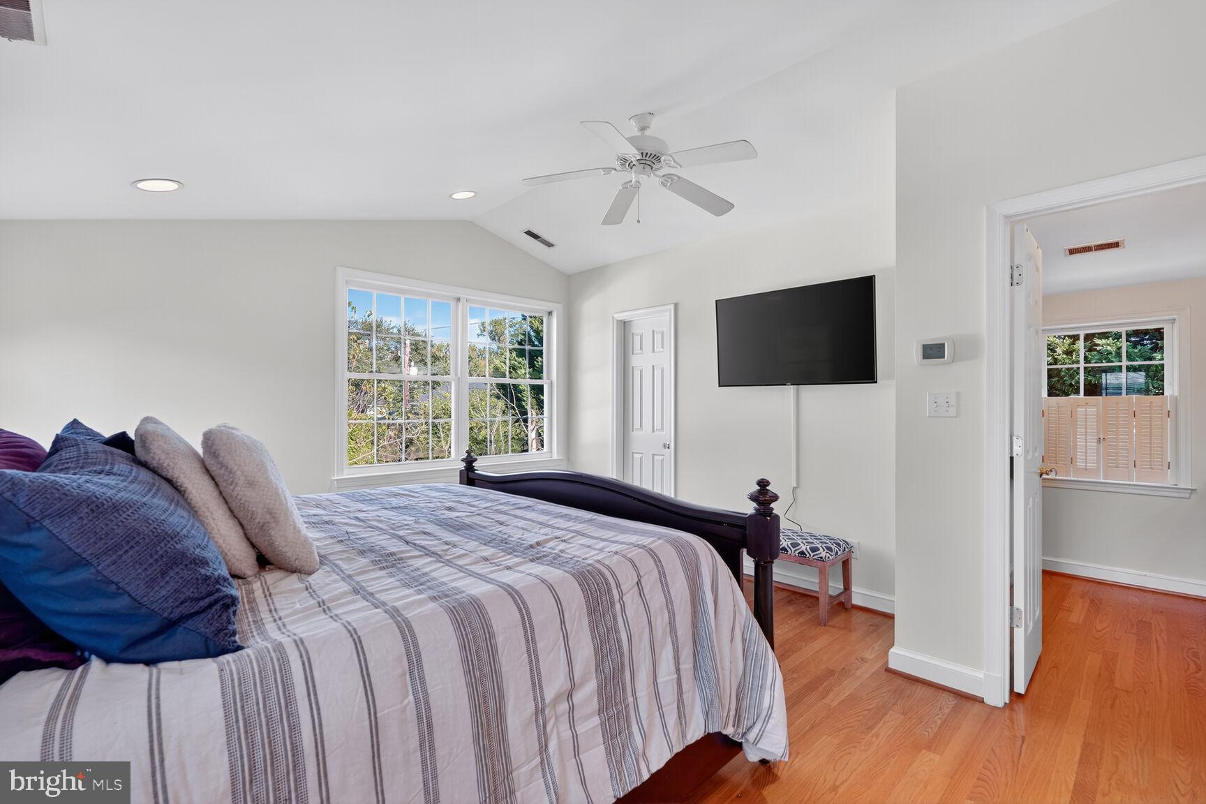 10406 Ewell Avenue Kensington, MD 20895 - Photo 31 of 42 a bedroom with a bed a flat screen tv and a chandelier