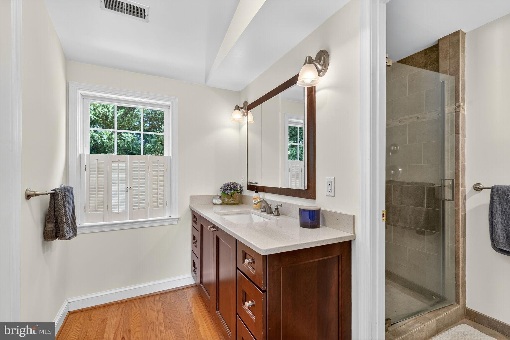 10406 Ewell Avenue Kensington, MD 20895 - Photo 33 of 42 a bathroom with a sink a mirror and shower