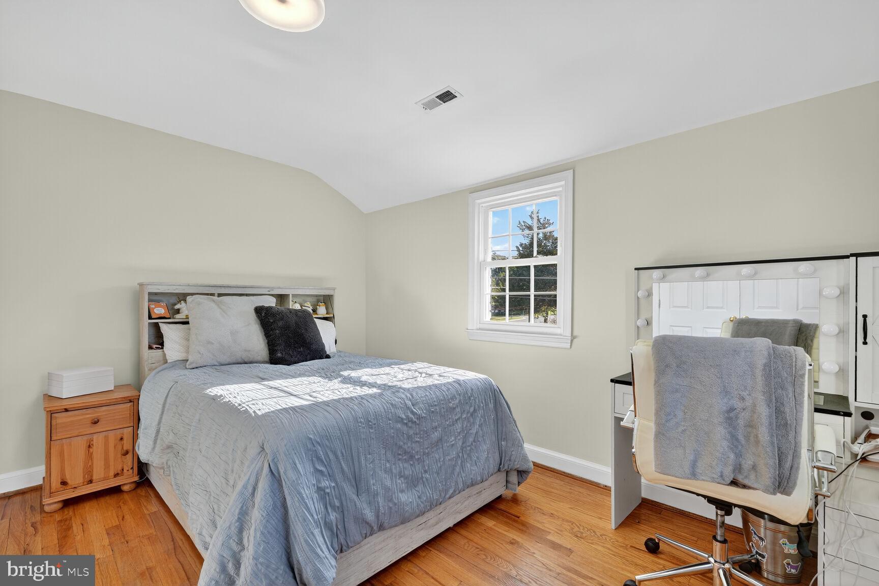 10406 Ewell Avenue Kensington, MD 20895 - Photo 38 of 42 a bedroom with a bed and wooden floor