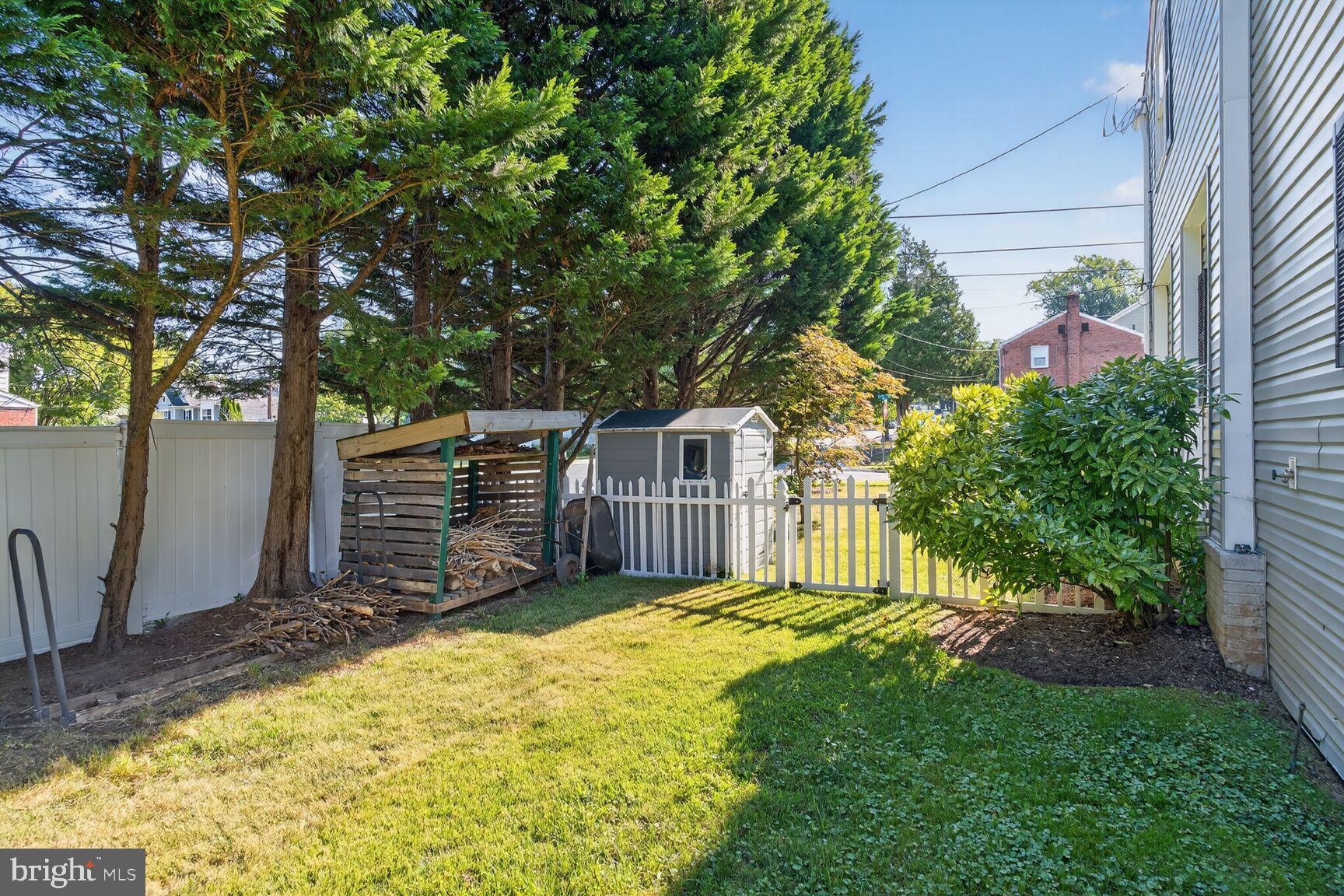 10406 Ewell Avenue Kensington, MD 20895 - Photo 9 of 42 a view of a wooden house with a large tree and wooden fence