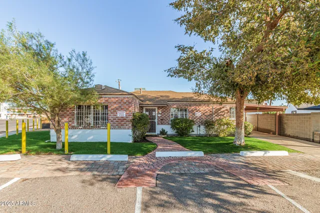 a view of a big house with a big yard and large trees