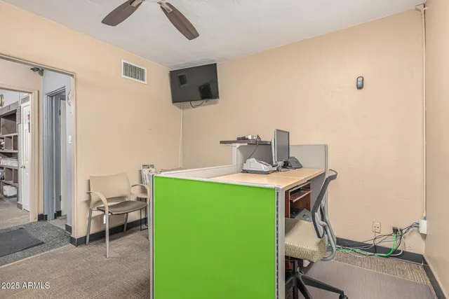 a work room with furniture and a flat screen tv
