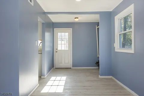 a view of empty room with windows and wardrobe
