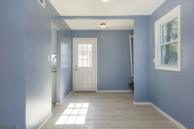 a view of empty room with windows and wardrobe