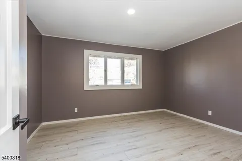 a view of a room with wooden floor and windows