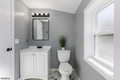 a bathroom with a toilet a sink and mirror