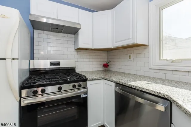 a kitchen with granite countertop a stove sink and cabinets