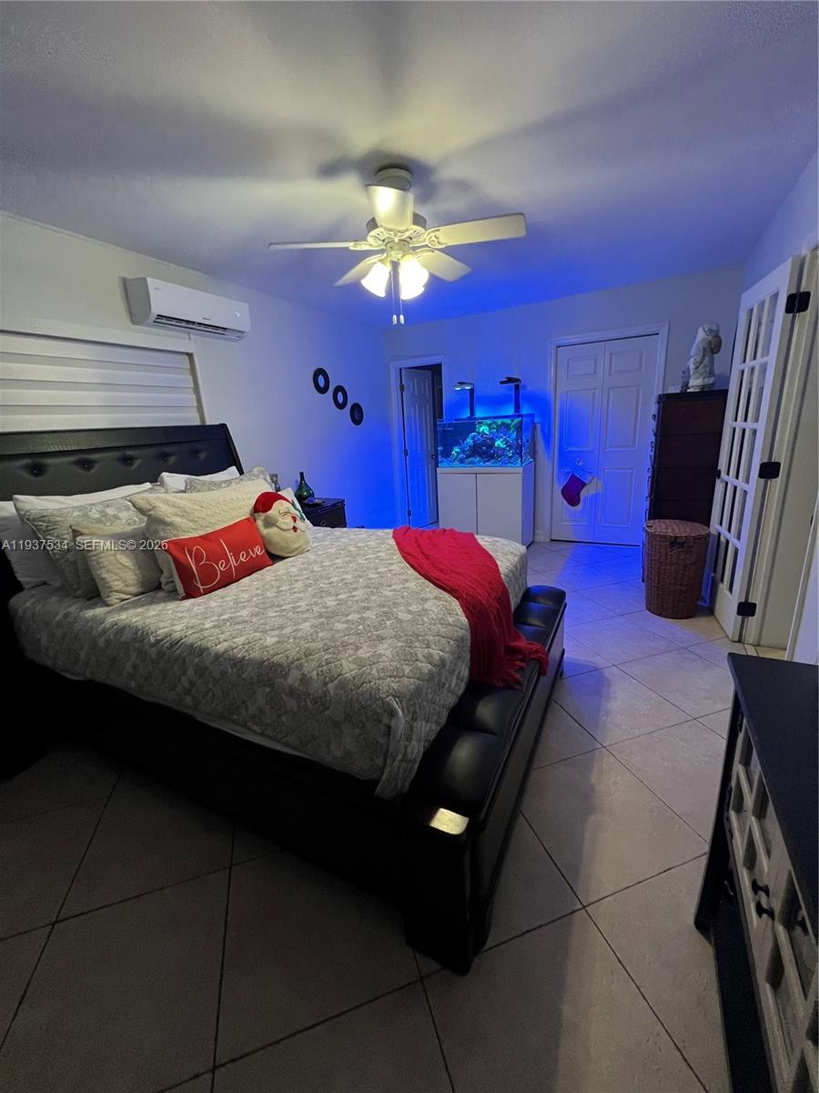 1461 East 9th Court Hialeah, FL 33010 - Photo 16 of 31 a bedroom with a bed and a chandelier
