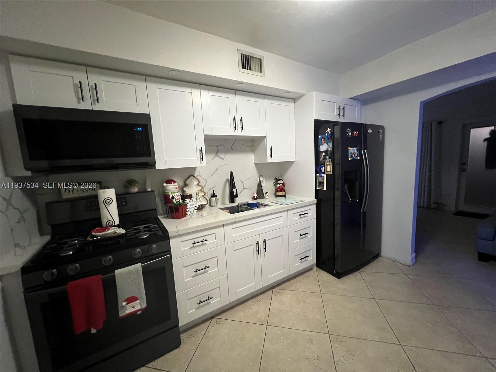 1461 East 9th Court Hialeah, FL 33010 - Photo 2 of 31 a kitchen with a refrigerator stove and microwave