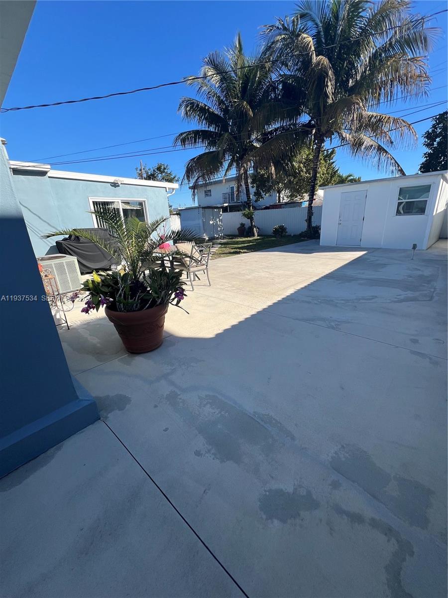 1461 East 9th Court Hialeah, FL 33010 - Photo 23 of 31 a view of a patio with dining table and chairs under an umbrella