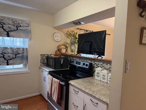 a kitchen with stainless steel appliances granite countertop a stove and a microwave