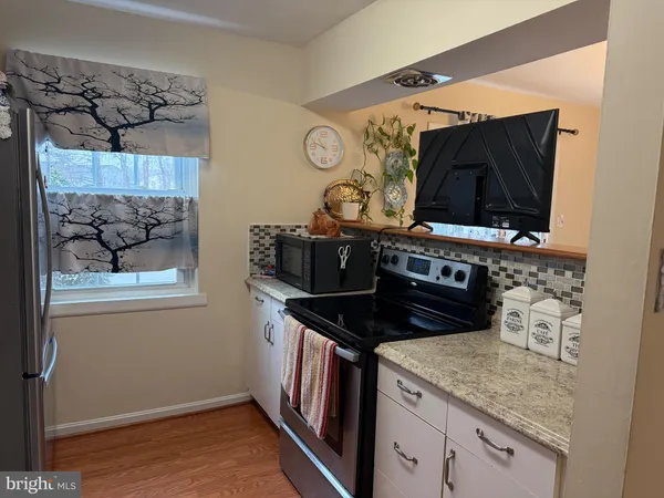 a kitchen with stainless steel appliances granite countertop a stove and a microwave