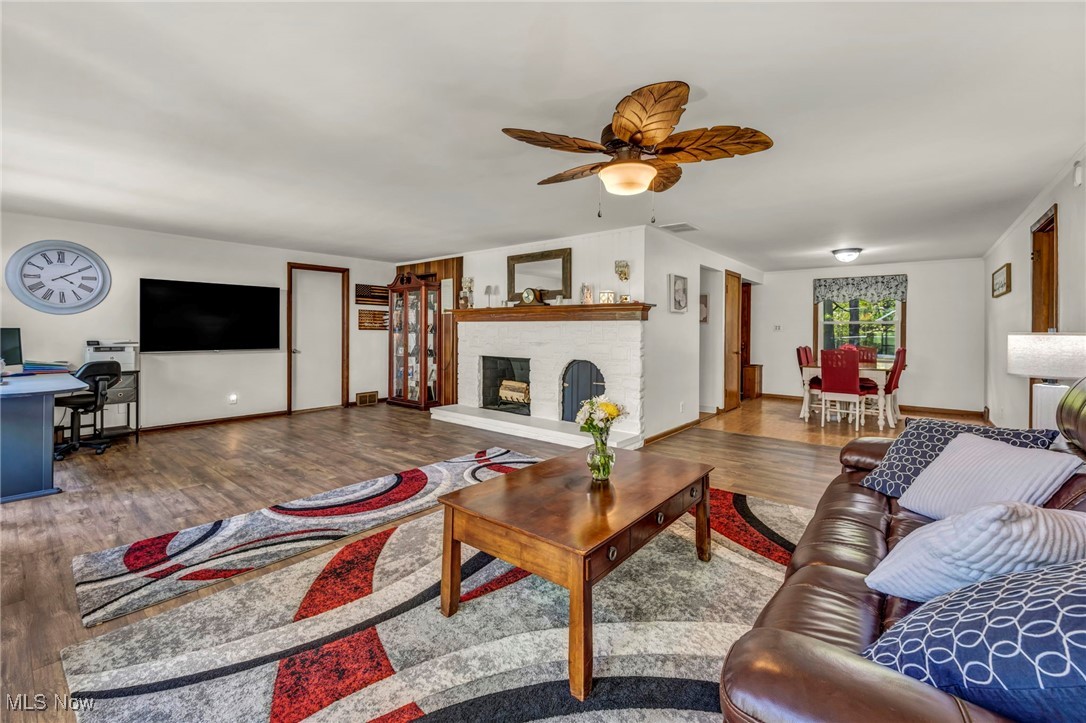8665 Johnnycake Ridge Road Mentor, OH 44060 - Photo 5 of 49 Living area featuring wood finished floors, ceiling fan, a fireplace, baseboards, and an office area