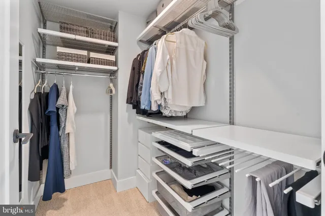 a view of walk in closet with clothes and shoes