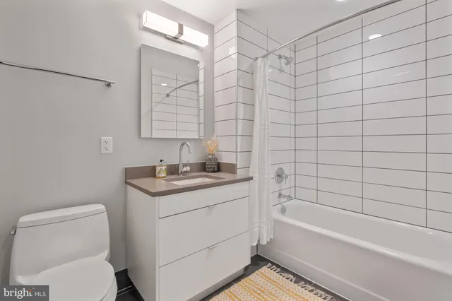 a bathroom with a granite countertop sink a toilet and bathtub