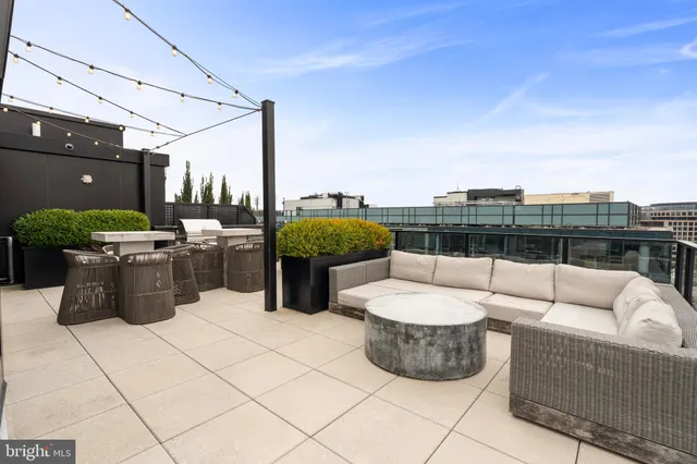 a view of a roof deck with couches and potted plants