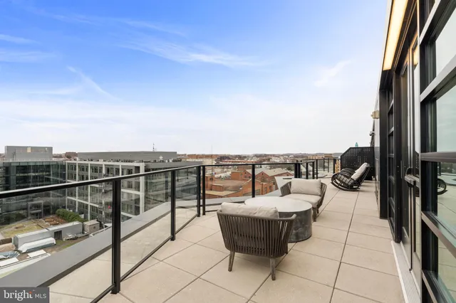 a view of a roof deck with couches and potted plants