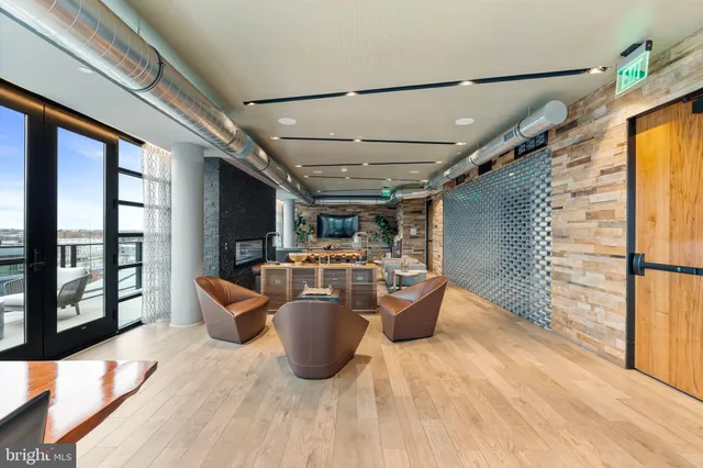 a view of a patio with couches potted plants with wooden floor