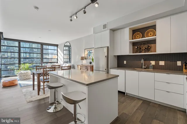a kitchen with a dining table chairs and white appliances