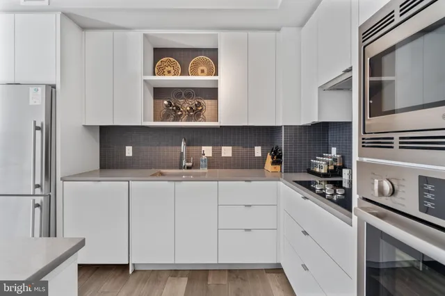 a kitchen with white cabinets and window