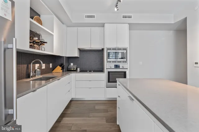 a kitchen with granite countertop white cabinets and refrigerator