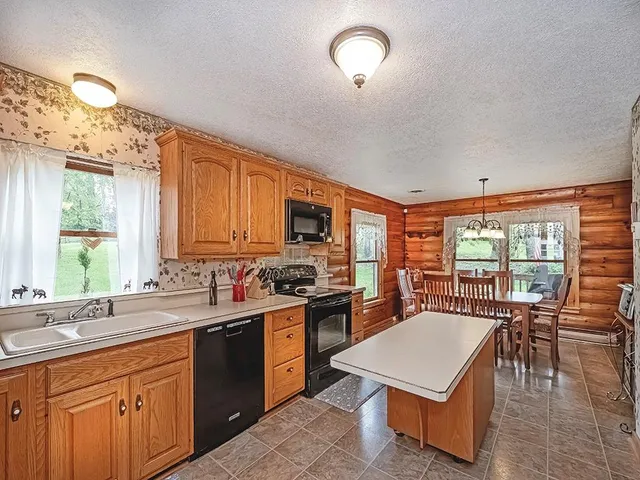 a kitchen with a stove a sink a dining table and chairs