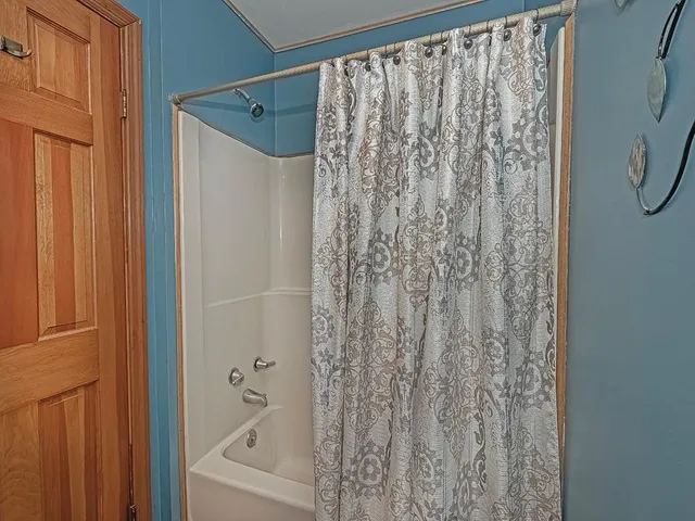 a bathroom with a shower curtain and a window