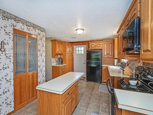 a kitchen that has a lot of cabinets a sink and a refrigerator