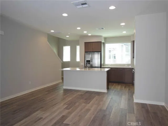 a large kitchen with a wooden floor and a sink