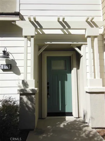 a view of a house with a door and wooden bench
