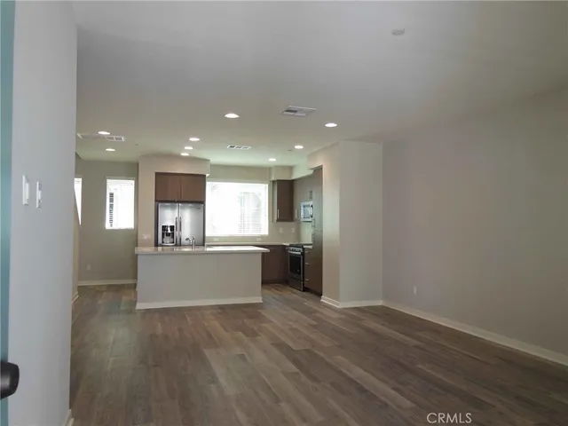 a kitchen with a wooden floor and window