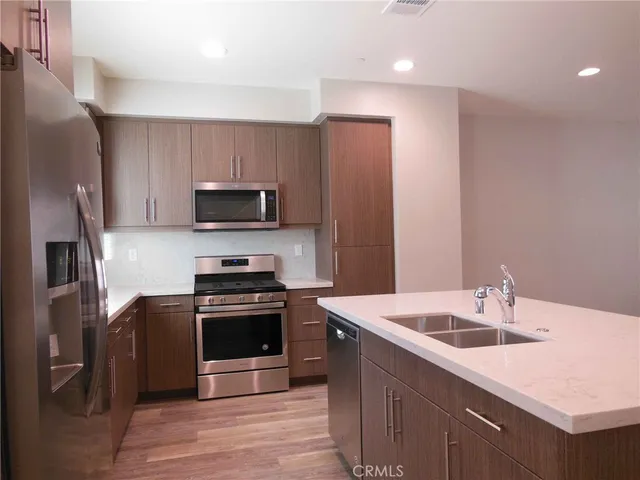 a kitchen with a sink a stove top oven and refrigerator