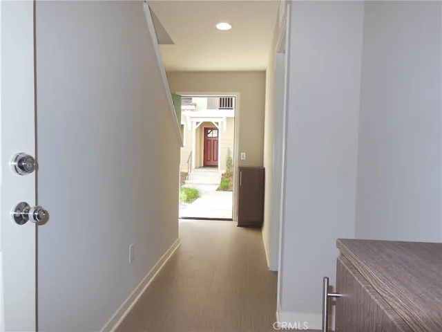 a view of a hallway with wooden floor and a living room