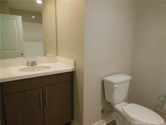 a bathroom with a sink mirror and toilet