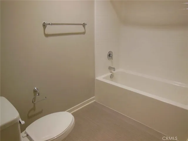 a white toilet sitting next to a bath tub