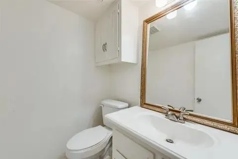 a bathroom with a sink a toilet and mirror