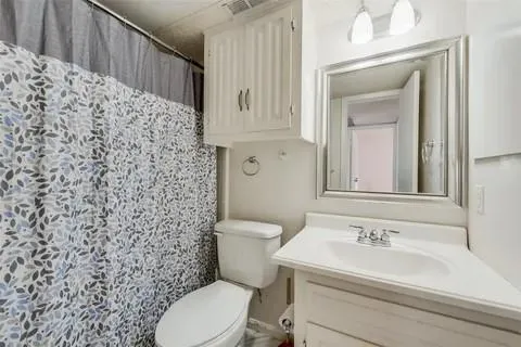 a bathroom with a sink a toilet and a mirror