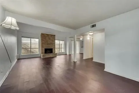a view of a livingroom with wooden floor and a fireplace