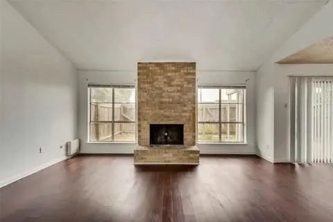 an empty room with floor to ceiling window and fireplace