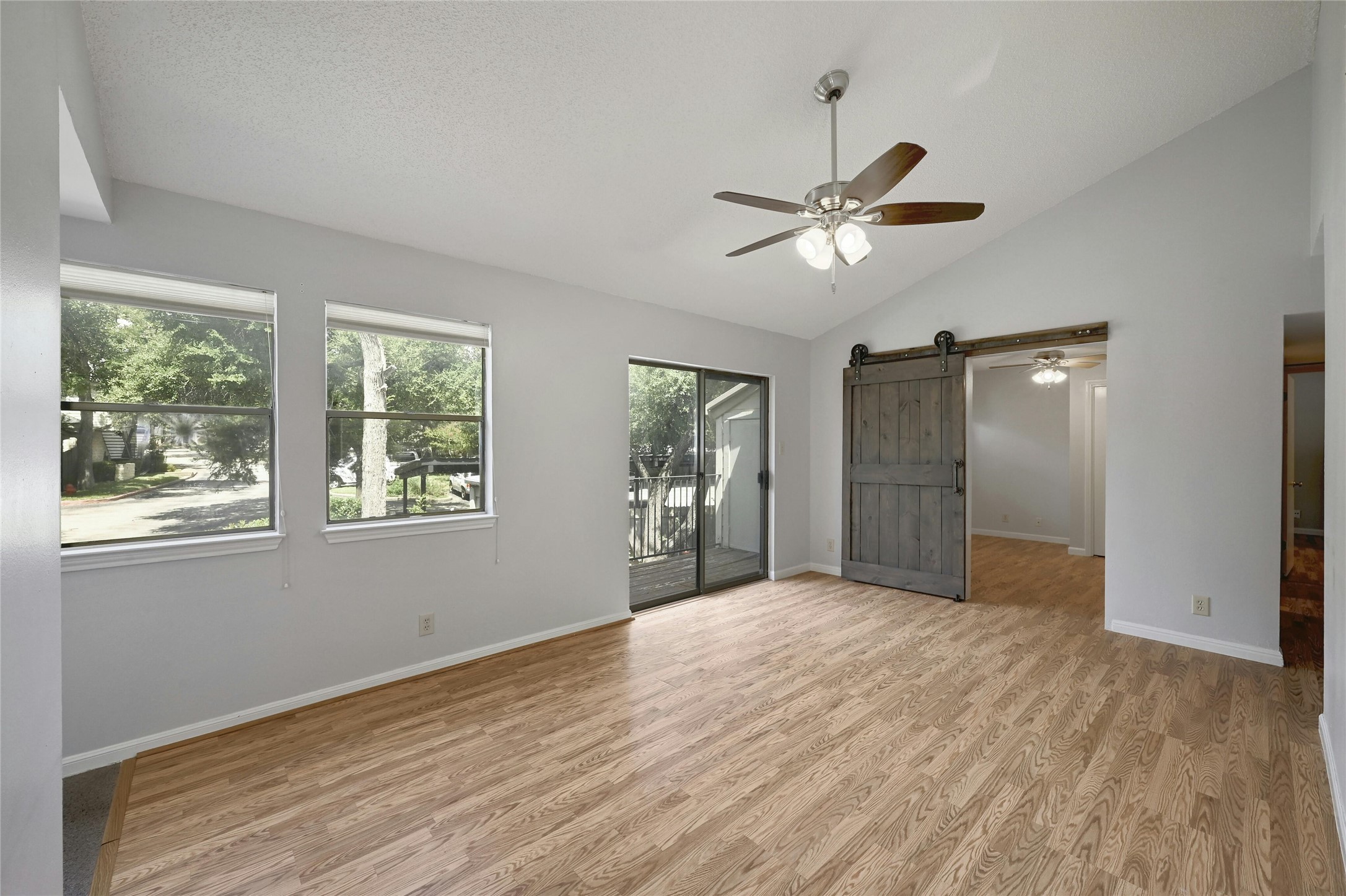 9226 Jollyville Road, Unit 221 Austin, TX 78759 - Photo 6 of 20 A wide living space features a sliding barn door and outdoor access.
